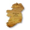 This personalised Irish wedding gift is a handmade wooden map of Ireland wall art, on a white background, engraved with the bride and groom's names, the date of their wedding, and a Celtic Claddagh Ring symbol.