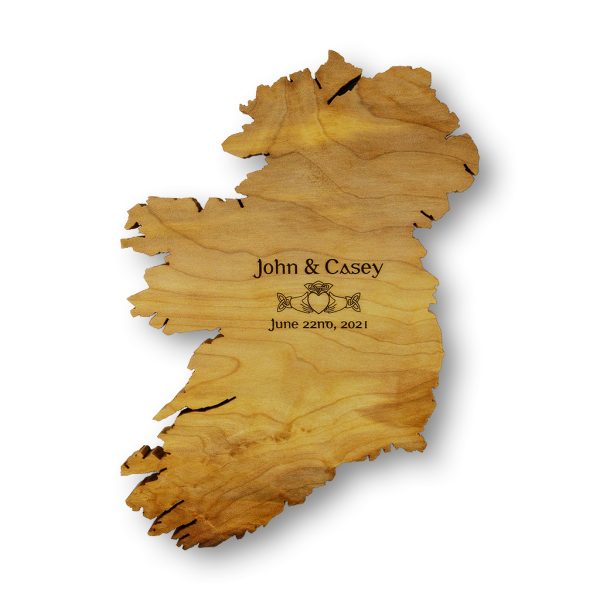 This personalised Irish wedding gift is a handmade wooden map of Ireland wall art, on a white background, engraved with the bride and groom's names, the date of their wedding, and a Celtic Claddagh Ring symbol.