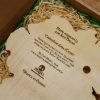 Back of a personalised Irish map clock, in a wood-wool filled gift box, engraved with text about the clock, and a gift message to the recipient.