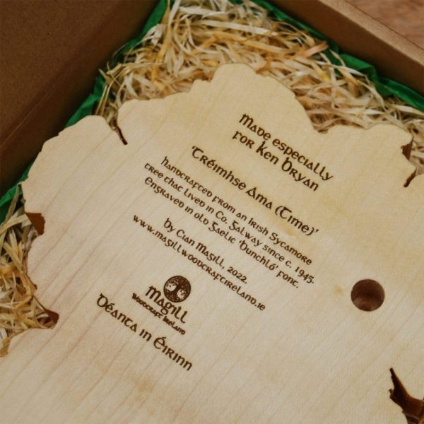 Back of a personalised Irish map clock, in a wood-wool filled gift box, engraved with text about the clock, and a gift message to the recipient.