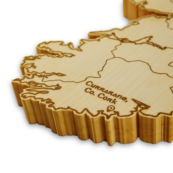 Close up of a wooden Ireland map jigsaw clock, engraved with Ireland's counties and the words 'Currarane, Co. Cork'.