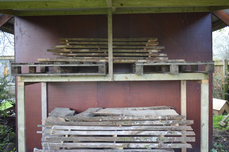 Air drying lean-to with stacked planks of Irish timber in.