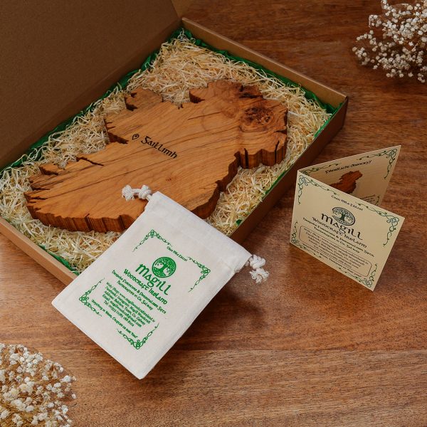 Magill Woodcraft Ireland screen-rpinted cotton bag on top of a wooden map of Ireland wall art that is in a cardboard gift box with wood wool and green tissue.